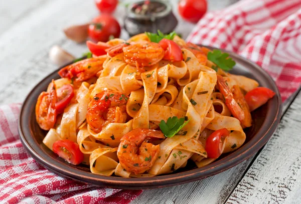 Fettuccine pasta med räkor, tomater och örter. — Stockfoto