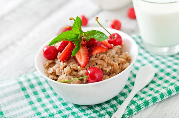 Bouillie d'avoine aux baies et verre de lait — Photo