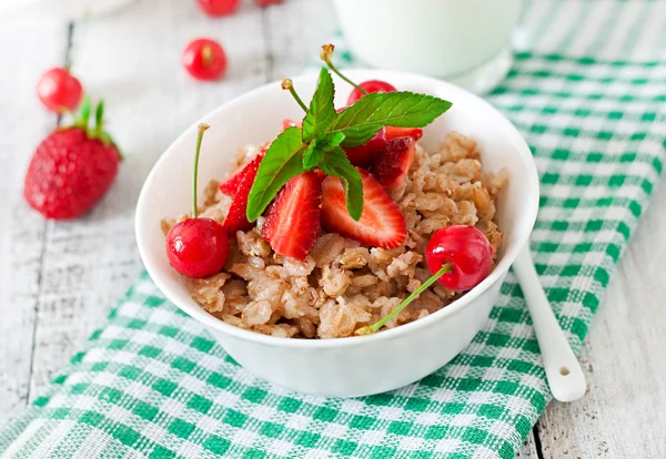 Gachas de avena con bayas y vaso de leche — Foto de Stock