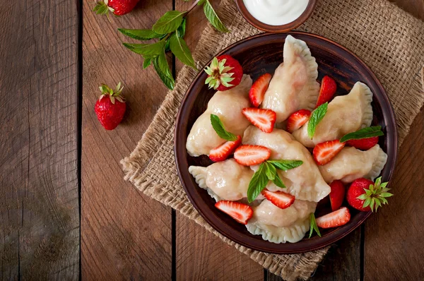 Dumplings with strawberries and sour cream — Stock Photo, Image