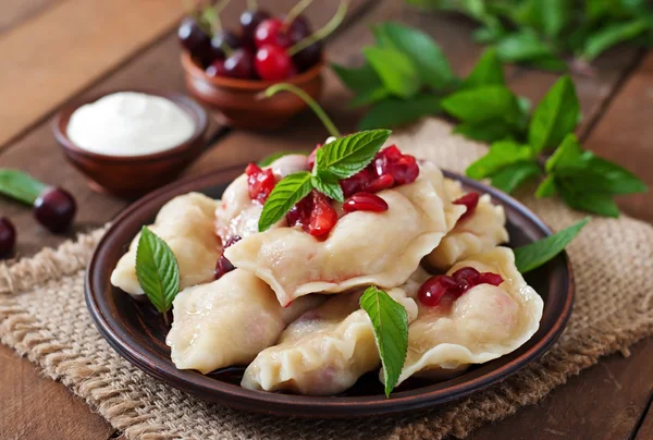 Dumplings with cherries and leaves — Zdjęcie stockowe