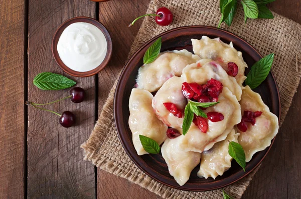 Dumplings with cherries and leaves — Stock fotografie