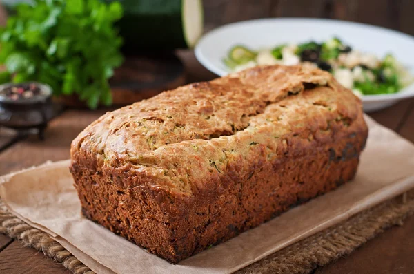Zucchini bread with cheese on a wooden background — Stock Photo, Image