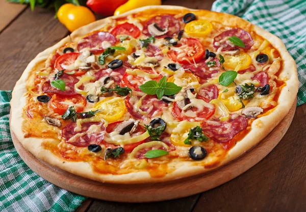 Pizza salamia, tomaattia, juustoa ja oliiveja — kuvapankkivalokuva