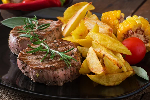 Steaks  with French fries and vegetables — Stock Photo, Image