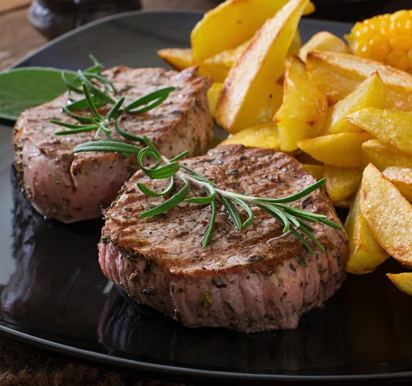 Steaks  with French fries and vegetables — Stock Photo, Image