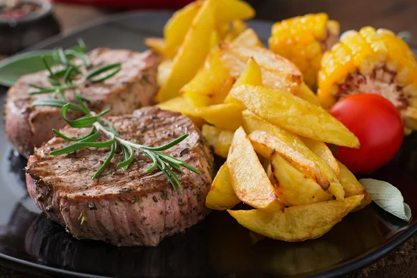 Steaks  with French fries and vegetables — Stock Photo, Image