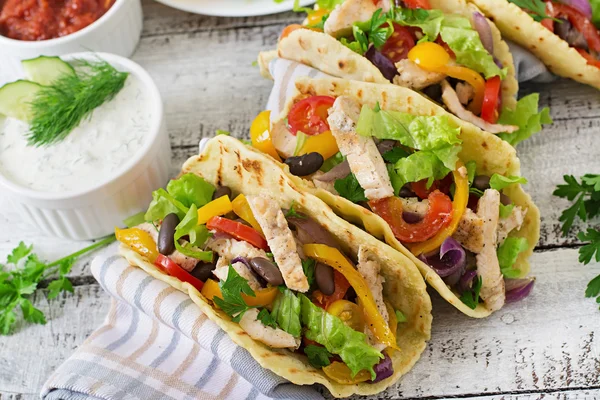 Mexican tacos with chicken, bell peppers, black beans and fresh vegetables — Stock Photo, Image