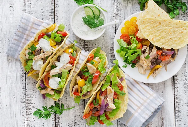 Tacos mexicanos com frango, pimentão, feijão preto e legumes frescos e molho tártaro — Fotografia de Stock