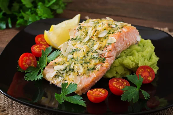 Salmão assado com queijo e crosta de amêndoa e decorado com purê de batatas e ervilhas verdes — Fotografia de Stock