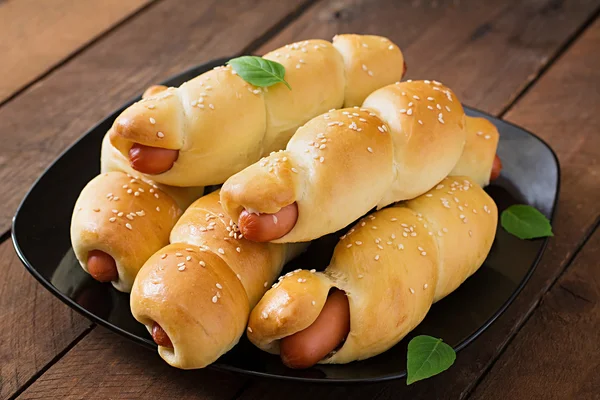 Sausage in the dough sprinkled with sesame seeds — Stock Photo, Image