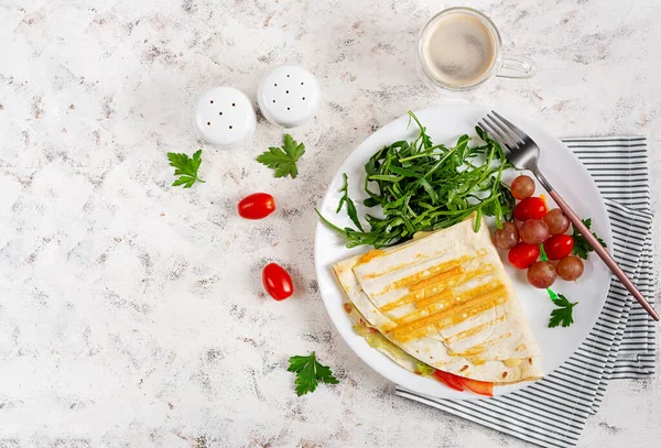 Healthy breakfast. Lavash with cheese, tomatoes, and herbs. Fresh salad. Top view