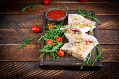 Traditional mexican quesadillas with sliced ham also called sincronizadas on wooden background. Overhead