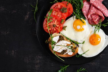 İngiliz kahvaltısı. Yağda yumurta, salam, domates ve peynirli tost. Üst görünüm.