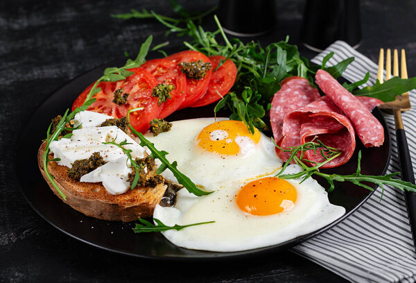 Английский завтрак. Жареные яйца, салями, помидоры и тосты с фета и песто.