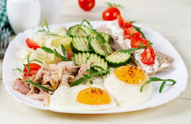 Ketogenik, paleo diyeti. Kızarmış yumurta, haşlanmış tavuk ve taze salata. Keto kahvaltısı. Kahvaltı.