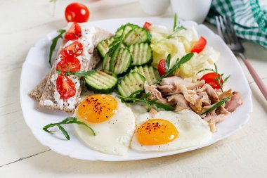 Ketogenik, paleo diyeti. Kızarmış yumurta, haşlanmış tavuk ve taze salata. Keto kahvaltısı. Kahvaltı.