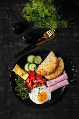 İngiliz kahvaltısı - kızarmış yumurta, jambon, yeşil fasulye, domates, salatalık ve tost. Üst görünüm