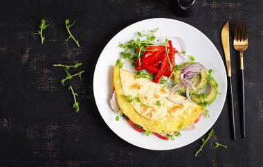 Sağlıklı kahvaltı. Omlet, köfte, peynir, domates ve sebzeli Quesadilla. Üst görünüm