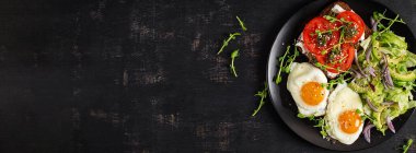 Kızarmış yumurta, taze salata ve domatesli sandviç, pesto ve krem peynir. Üst Manzara. Pankart