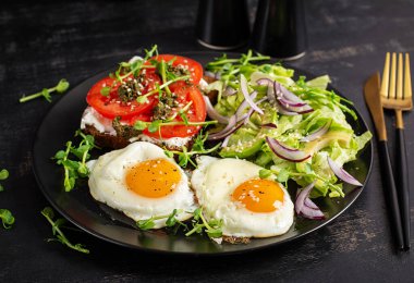Kızarmış yumurta, taze salata ve domatesli sandviç, pesto ve krem peynir..