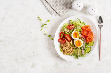Kahvaltı yulaf lapası haşlanmış yumurta, tuzlu somon, domates, salatalık ve kırmızı soğan. Sağlıklı dengeli yiyecekler. Moda yiyecekler.
