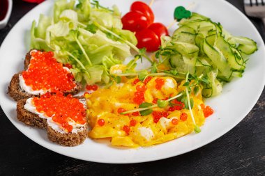 Romantik kahvaltı. Sevgililer Günü. Omlet, kırmızı havyarlı sandviç ve salata..