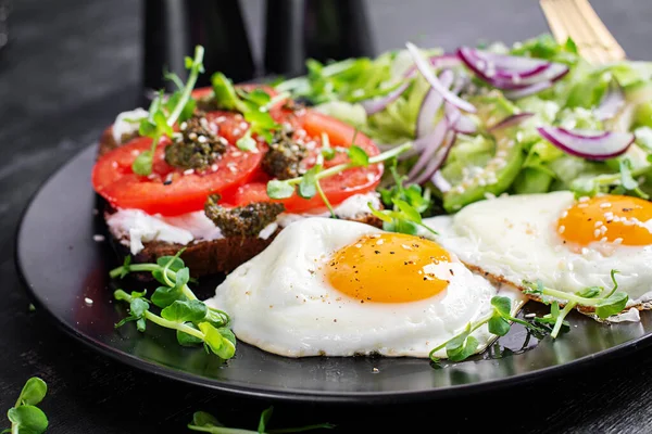 Kızarmış yumurta, taze salata ve domatesli sandviç, pesto ve krem peynir..