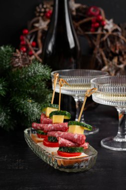 Salamlı, peynirli, domatesli kanepeler. Noel ve yeni yıl yemekleri. Tatil masası için atıştırmalık ve şarap..