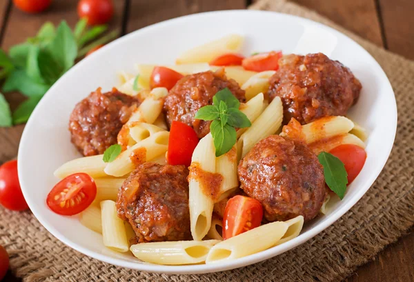 Penne pasta with meatballs in tomato sauce Stock Photo