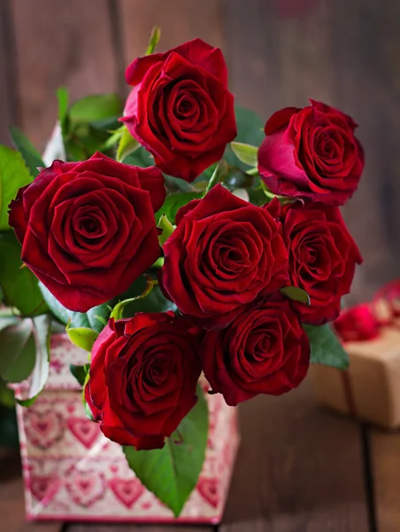 Bouquet di rose rosse con regalo — Foto Stock