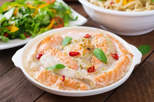 Baked slices of red and white fish with honey and lime juice, served with fresh salad and soft noodles — Stock Photo, Image