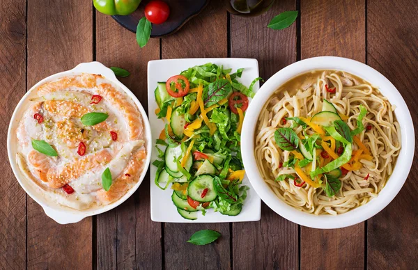 Baked slices of red and white fish with honey and lime juice, served with fresh salad and soft noodles — Stock Image Baked slices of red and white fish with honey and lime juice, served with fresh salad and soft noodles Stock Picture
