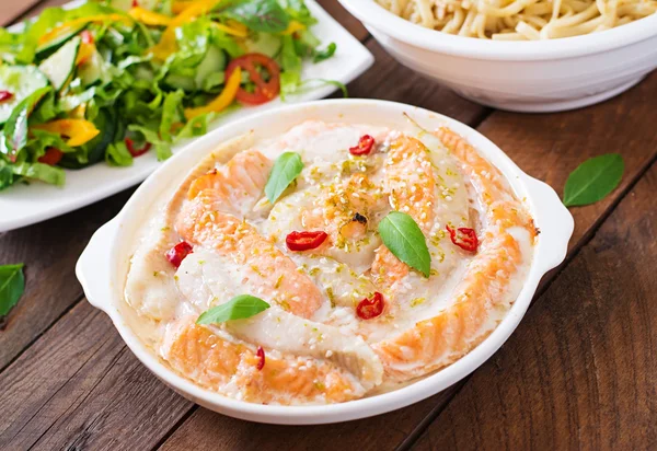 Baked slices of red and white fish with honey and lime juice, served with fresh salad and soft noodles — Stock Image Baked slices of red and white fish with honey and lime juice, served with fresh salad and soft noodles Stock Image