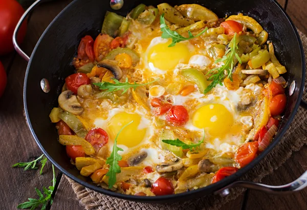 Ovos fritos com legumes em uma panela de ato de fritar — Fotografia de Stock