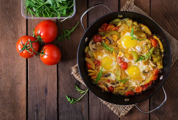 Fried eggs with vegetables in a frying pan — Stock Photo, Image