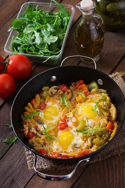 Fried eggs with vegetables in a frying pan — Stock Photo, Image