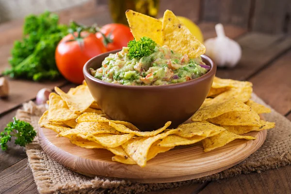 Guacamole avokado, lime, tomat, lök och koriander, serveras med nachos — Stockfoto