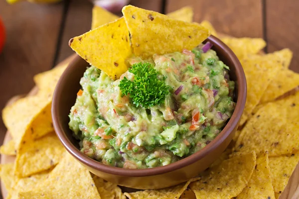 Guacamole alpukat, kapur, tomat, bawang bombay dan cilantro, disajikan dengan nachos — Stok Foto