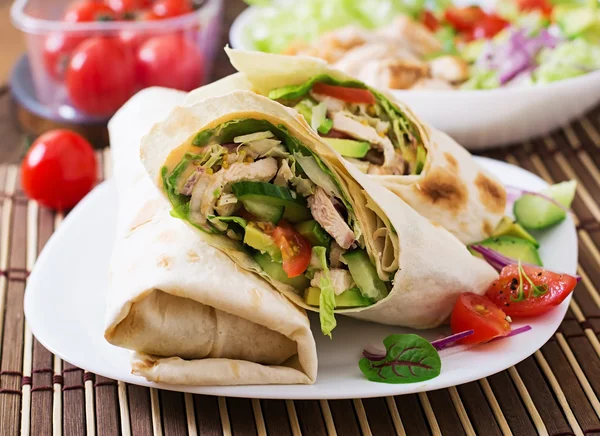 Tortilla fresca envolve com frango e legumes frescos no prato — Fotografia de Stock