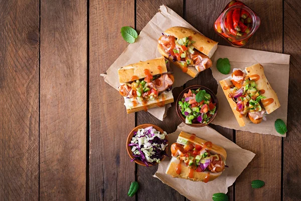 Hot dog - sandwich cu salsa mexicană pe fundal din lemn . — Fotografie, imagine de stoc