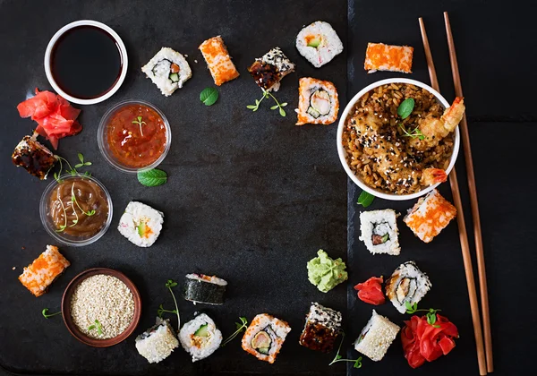 Traditional Japanese food - sushi, rolls, rice with shrimp and sauce on a dark background. — Stockfoto