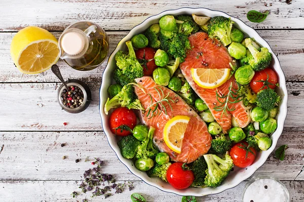 Bistecca di salmone crudo e verdure per cucinare su uno sfondo di legno chiaro in stile rustico . — Foto Stock