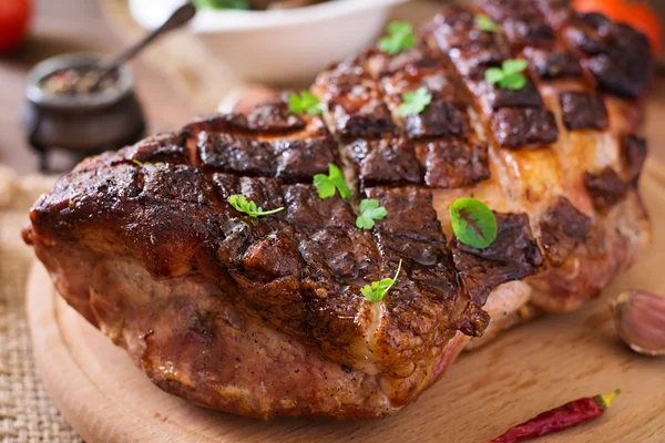 Pieczone mięso z przyprawami i czosnkiem na drewnianym stole — Zdjęcie stockowe