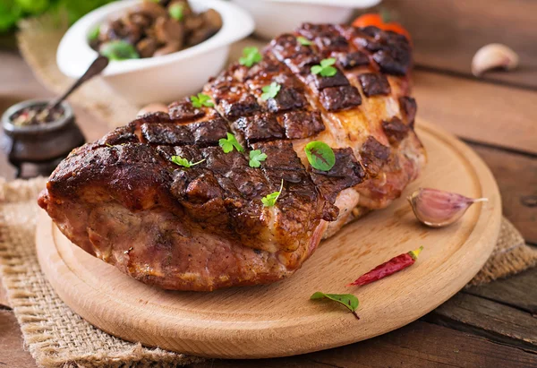 Baked meat with spices and garlic on wooden table — Stock Photo, Image