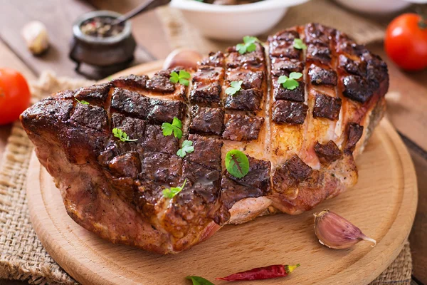 Baked meat with spices and garlic on wooden table — Stock Photo, Image