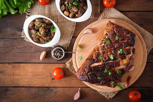 Bakade kött med kryddor och vitlök på träbord — Stockfoto