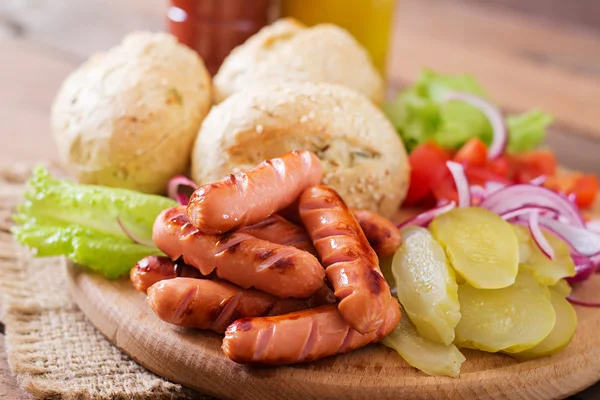Ингредиенты для приготовления хот-дога - сэндвич с огурцами, красный лук и салат на деревянном фоне — стоковое фото