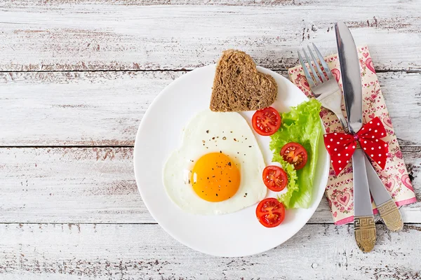 Frühstück am Valentinstag - Spiegeleier und Brot in Herzform — Stockfoto