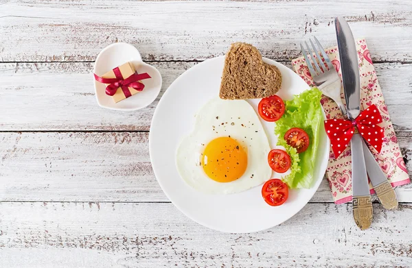 Café da manhã no Dia dos Namorados - ovos fritos e pão na forma de um coração — Fotografia de Stock